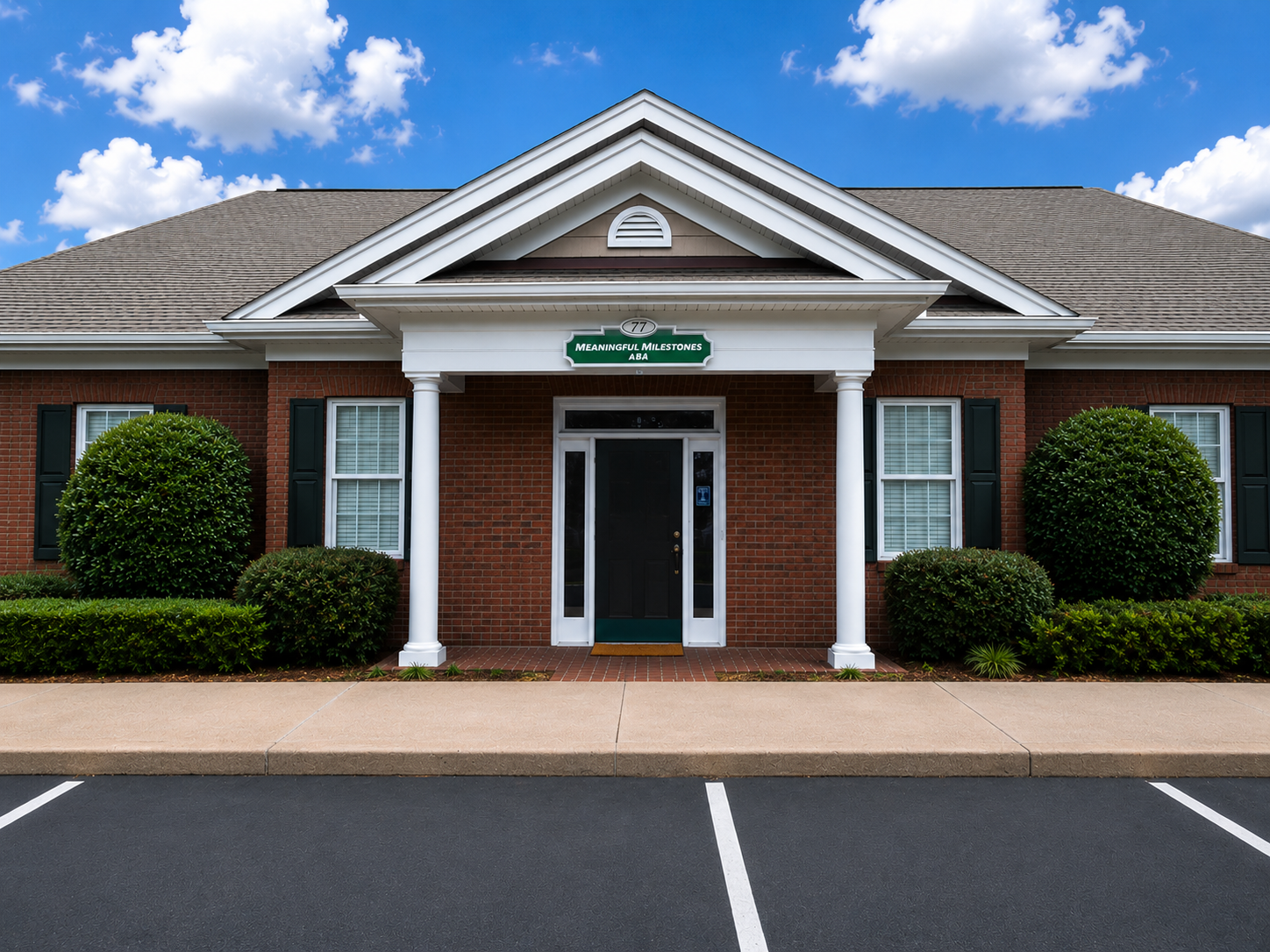 Exterior of the Meaningful Milestones ABA clinic in Alpharetta, Georgia — a brick building with white columns and a green entrance sign